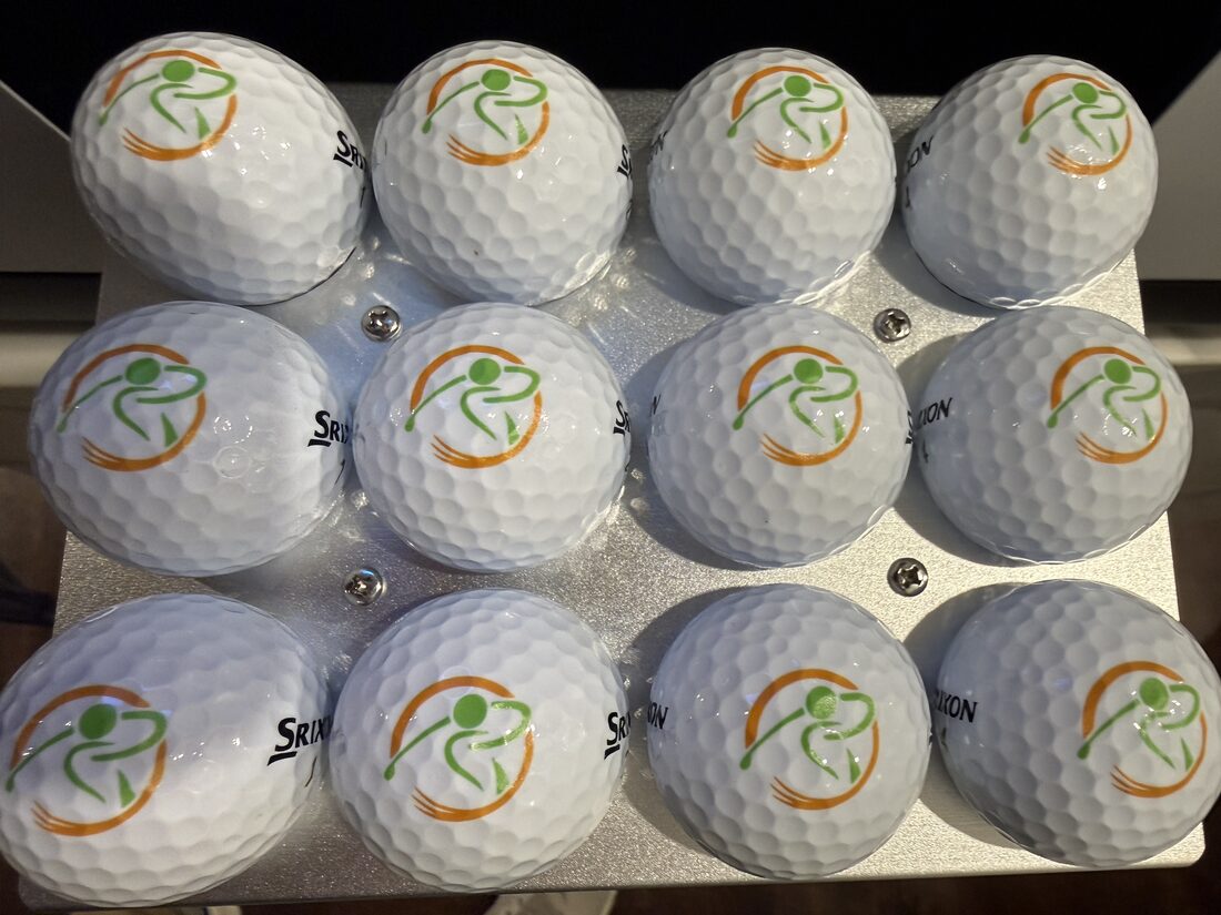 A dozen premium golf balls printed with a green and orange golfer swing logo